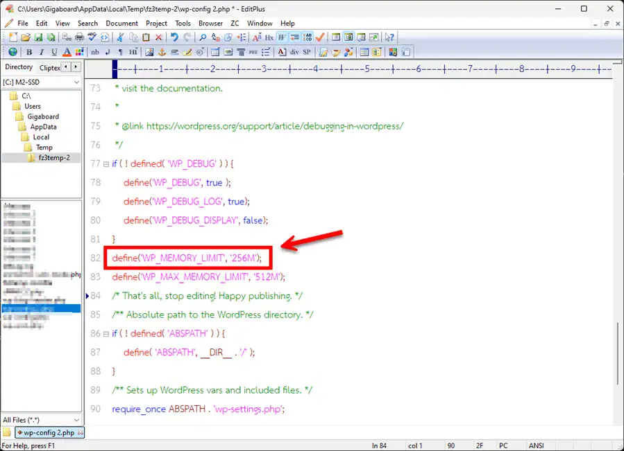A screenshot of a code editor displaying the wp-config.php file. A red arrow points to a red box highlighting the code snippet define('WP_MEMORY_LIMIT', '256M'); which is inserted just above the 'That's all, stop editing' line to increase the WordPress PHP memory limit.